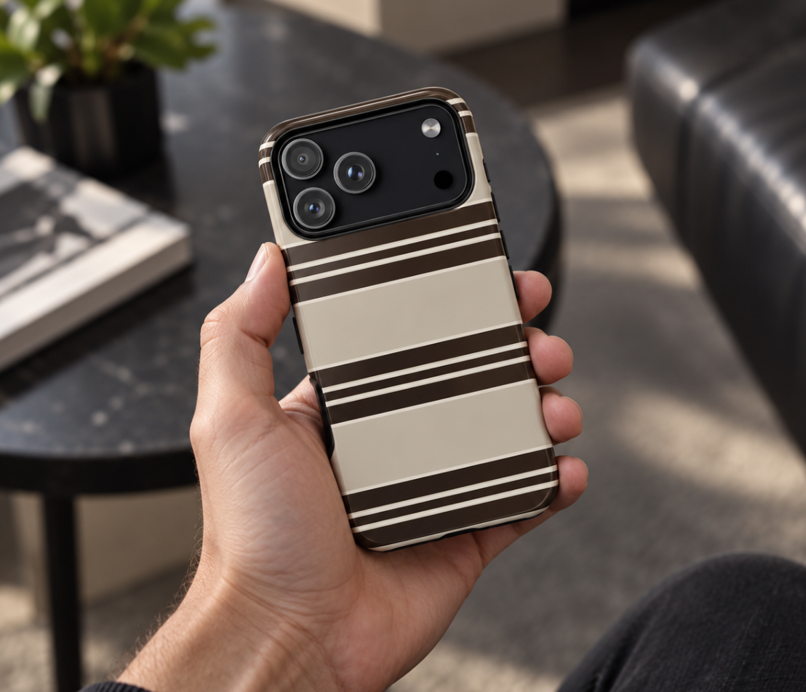Hand houdt een crème telefoonhoesje met bruine strepen vast