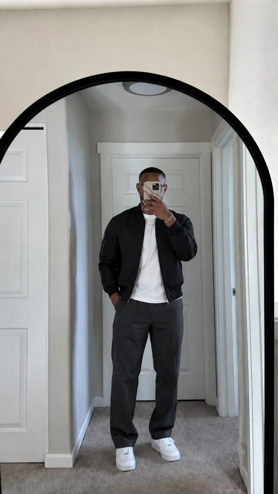 Man in zwart jack maakt een spiegelselfie met zijn telefoonhoesje